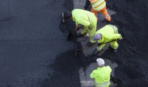 workers during asphalting road work on city street 2022 12 16 11 16 29 utc Ulicu v Nových Zámkoch na mesiac uzavrú. Opravená mala byť už minulý rok